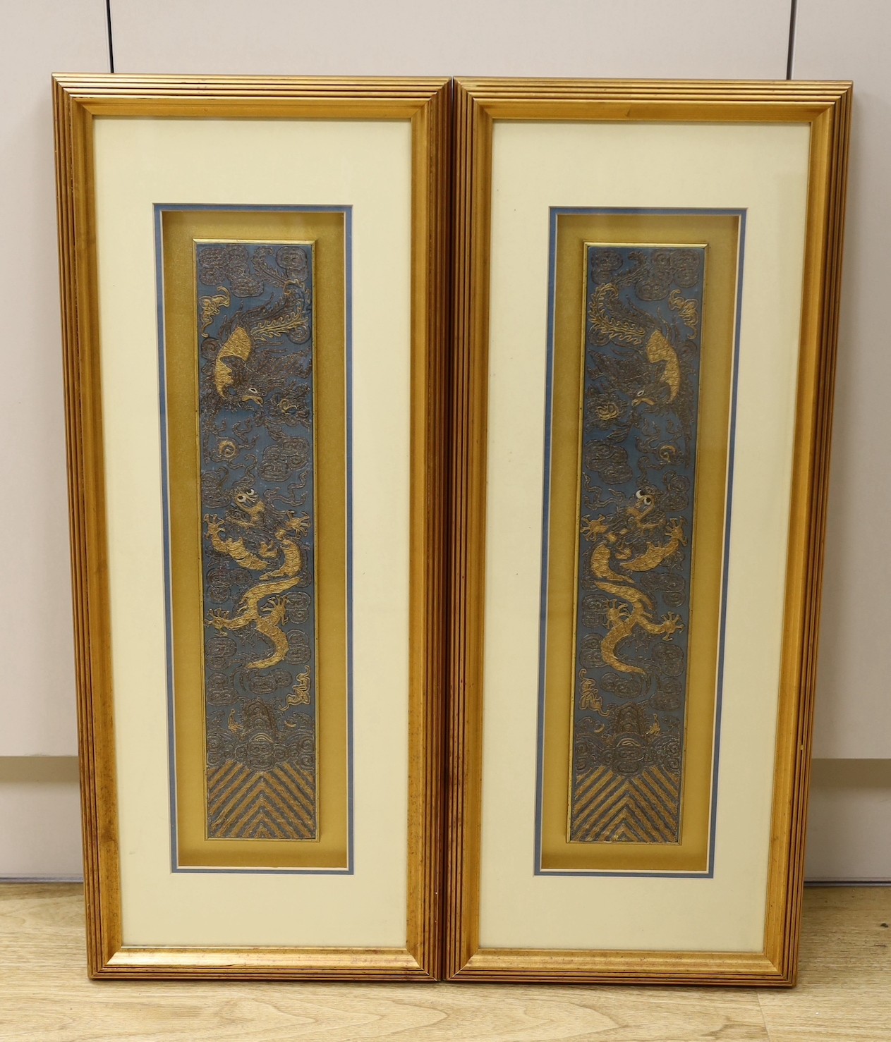 A pair of framed early 20th century Chinese metal thread embroidered ‘dragon’ design sleeve bands, 48x9cms excl frame